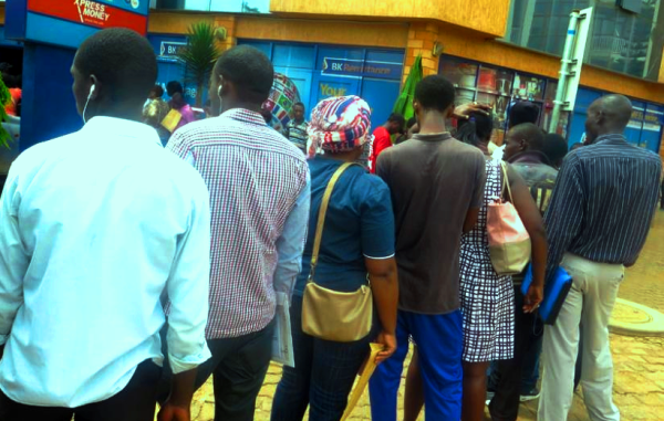 Clients queue outside a bank waiting to be served despite surge of ATMs